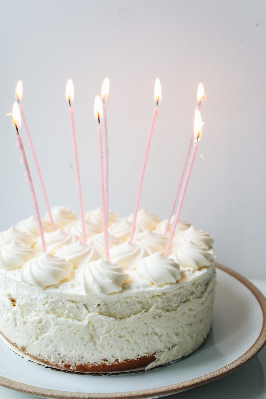 photo of white cake with candles on top