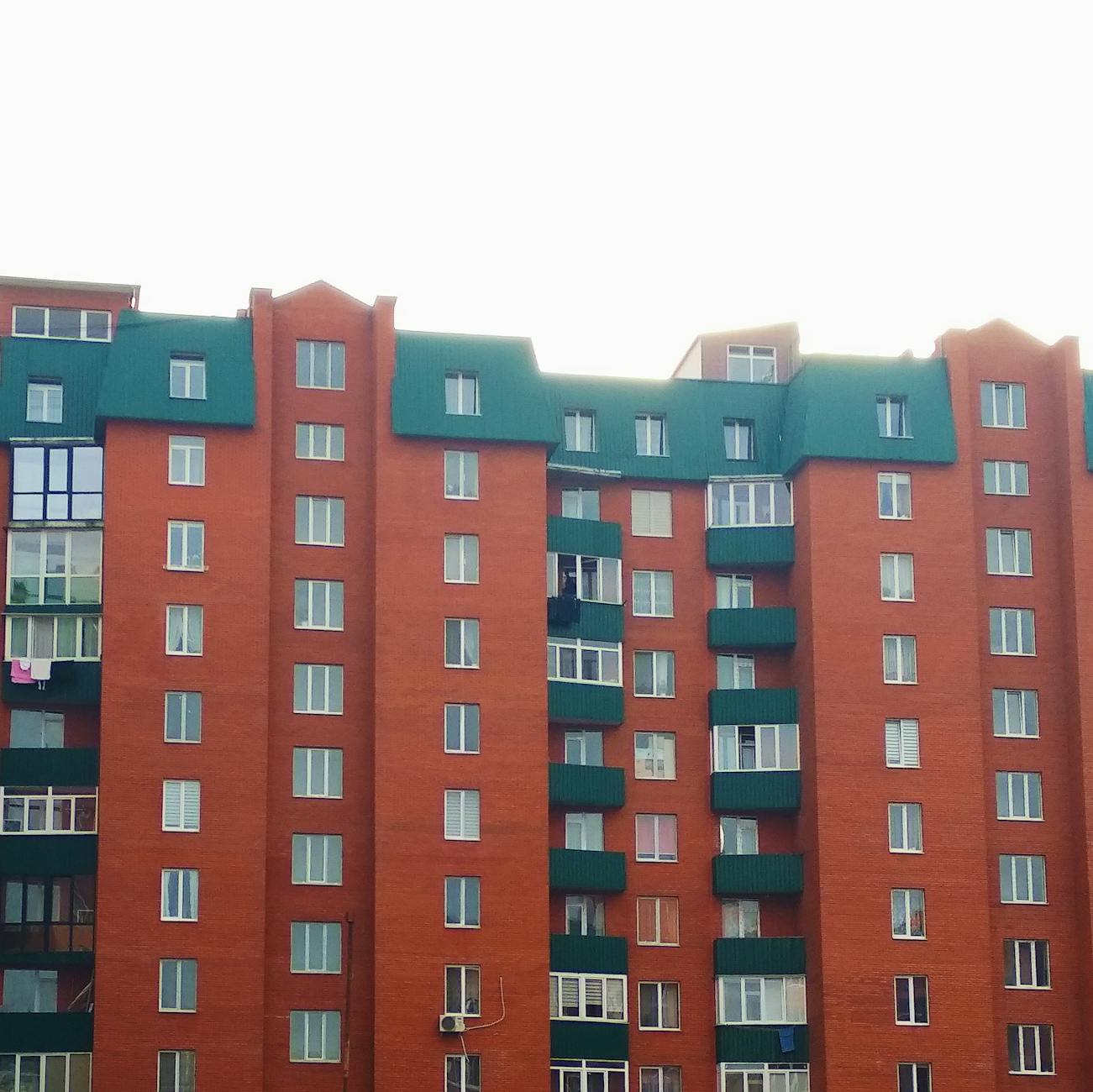 modern block of flats with green roof and balconies
