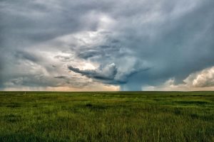 grass field below clouds