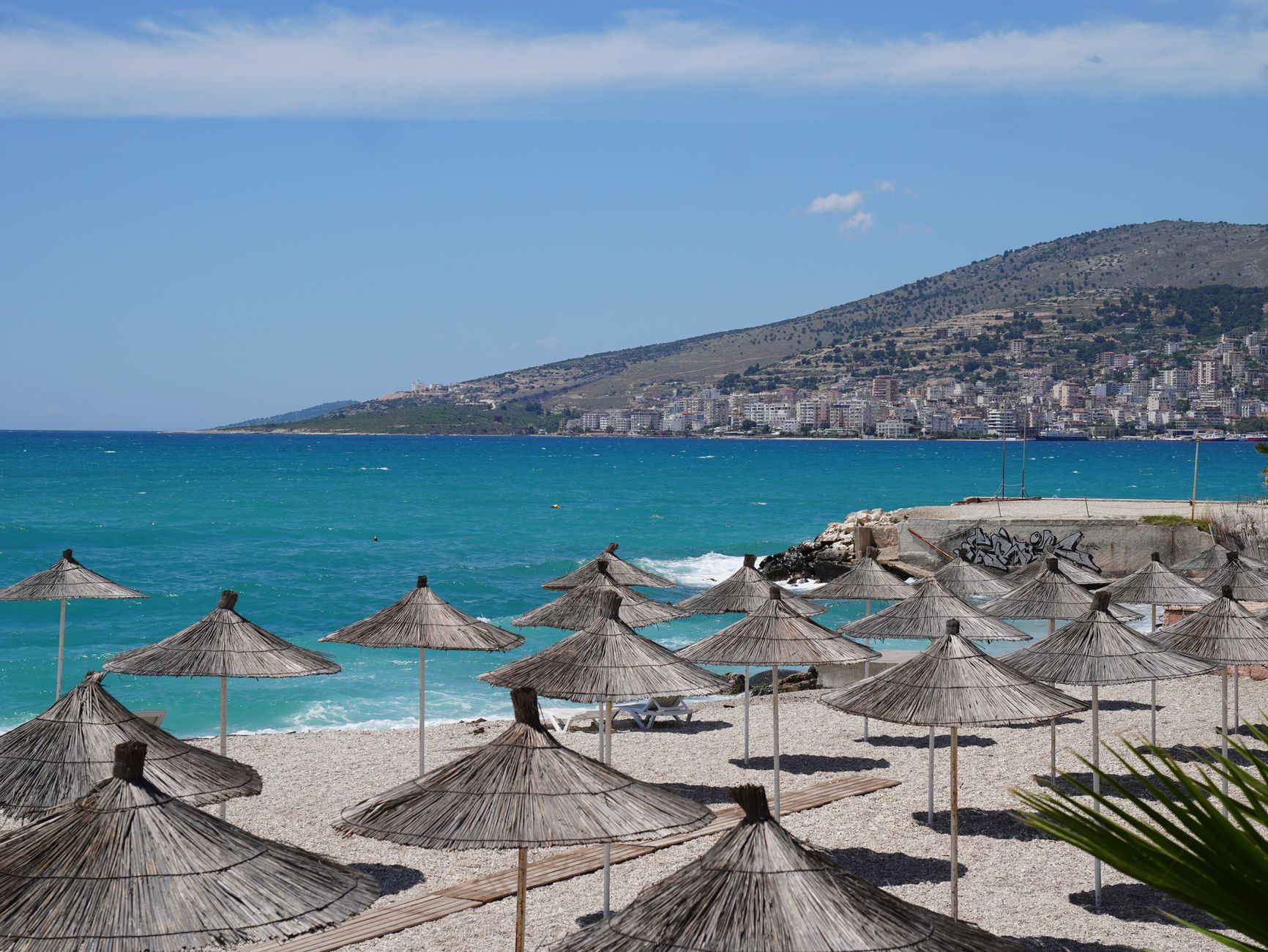 sunny beach with umbrellas on mediterranean coast