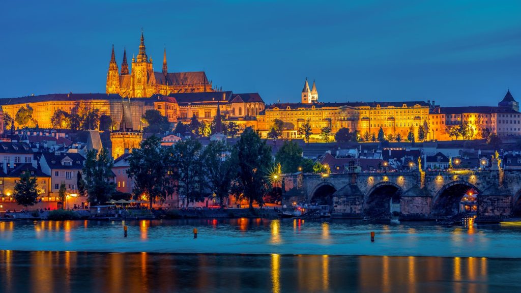 reflection of illuminated lights of prague castle on the lake